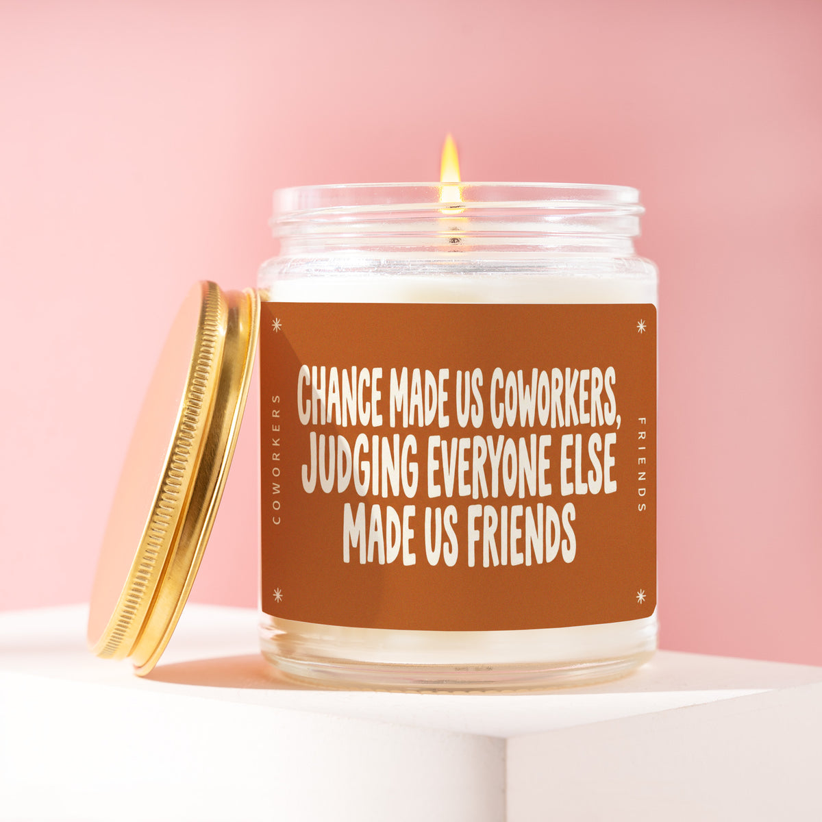 Chance Made Us Coworkers, Judging Everyone Else Made Us Friends 9 oz soy candle with a brushed gold lid by James Wax