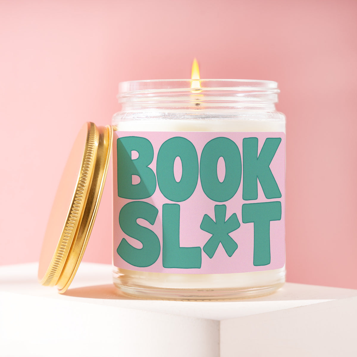 Book Sl*t 9 oz soy candle with a brushed gold lid by James Wax