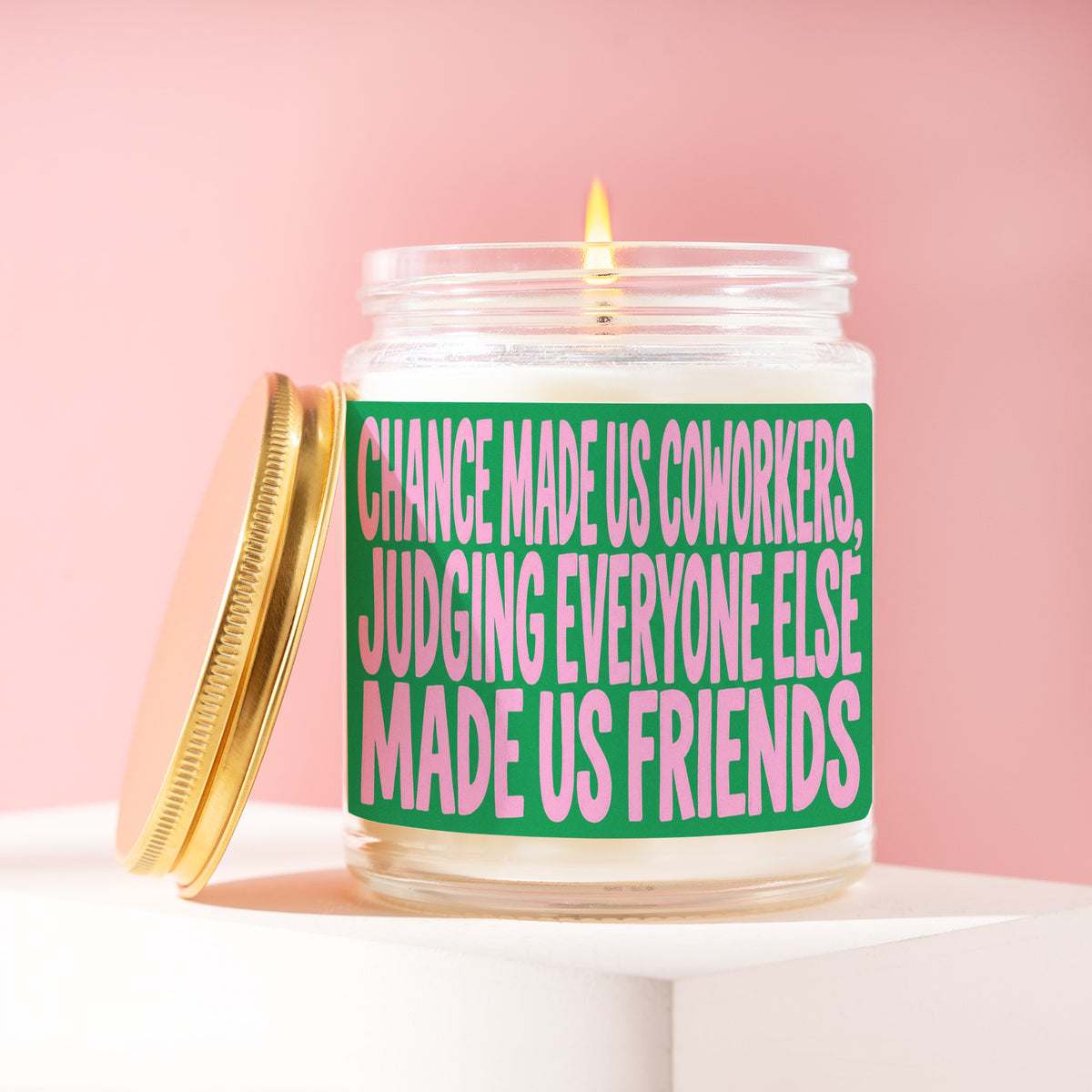Chance Made Us Coworkers, Judging Everyone Else Made Us Friends 9 oz soy candle with a brushed gold lid by James Wax