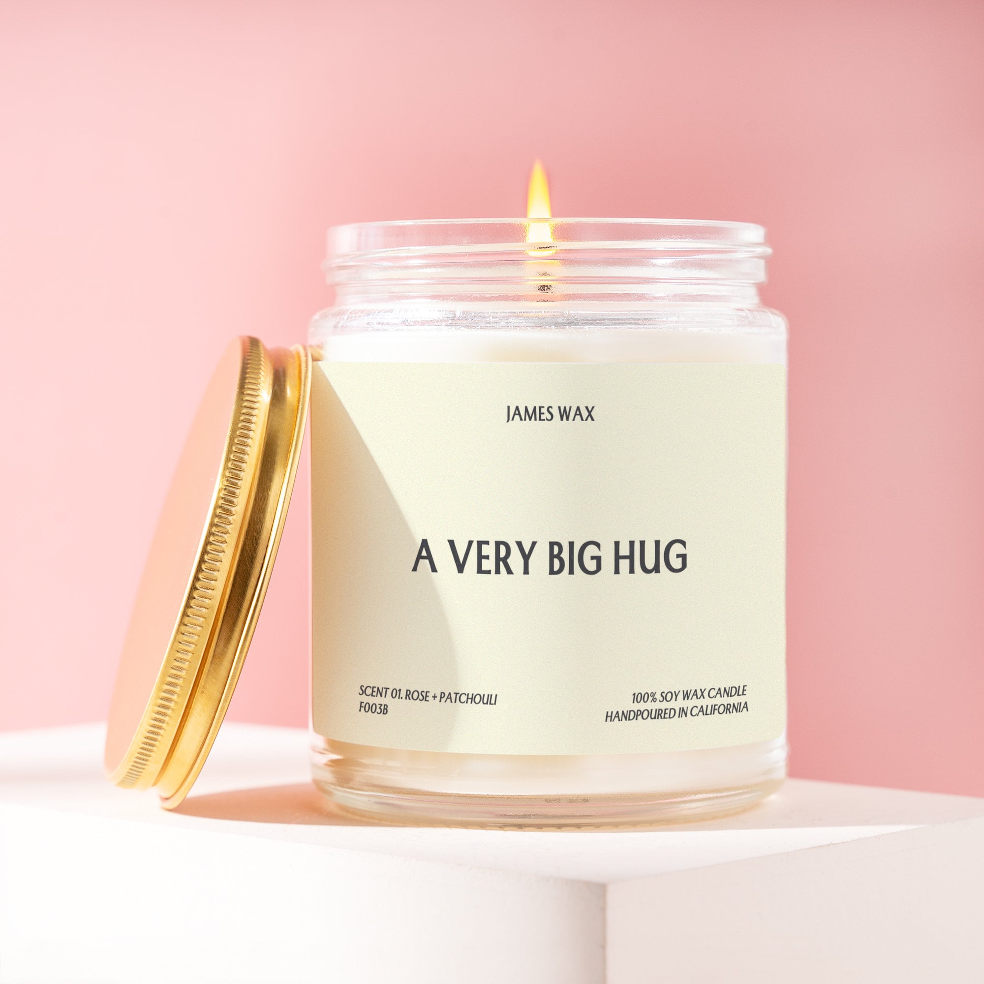 a very big hug candle with a gold lid